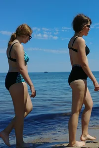 2 sexy friends in bikinis walking on the beach