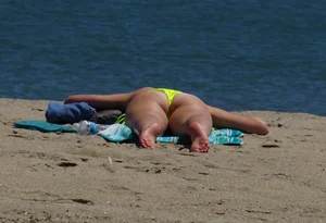 Sexy ass blonde milf on the beach in a thong with cameltoe and bending over