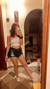 A Very Sexy Girl in a Top, Fringed Shorts And Short Socks Taking a Mirror Selfie at Home