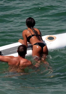 Black girl on the beach in a bikini with an incredible ass while surfing