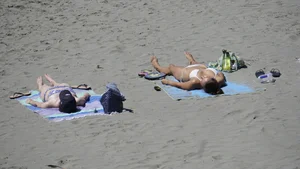 Sexy beach girl laying out in white bikini with nice body