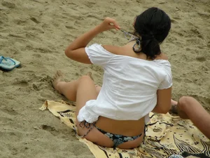 Sexy girl in a blue floral thong bikini at the beach