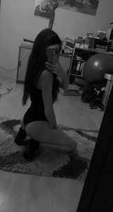 Black and White Mirror Selfie of a Girl in Socks and a Body Standing on Her Knees on the Floor