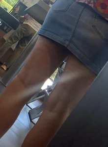 Legs closeups of a girl in jean skirt wearing sandals