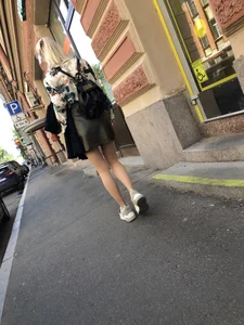 Nice slim legs of a candid girl wearing a leather skirt