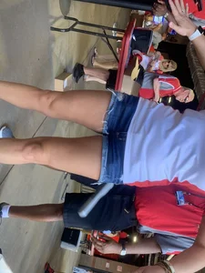 Bunch of girls in various outfits at a Cardinals baseball game