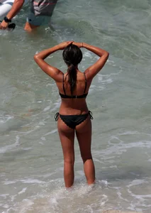Black girl on the beach in a bikini with an incredible ass while surfing