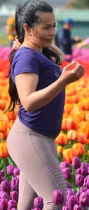 Cute babe in tight leggings taking pictures in flower fields