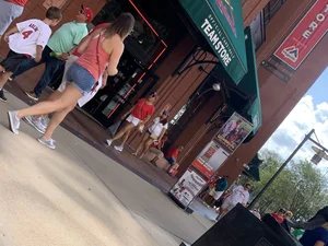 Bunch of girls in various outfits at a Cardinals baseball game