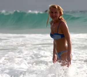Blonde milf in a blue bikini looking sexy at the beach