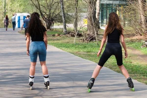 Girs in Shorts on Roller Blades in the Park Candid