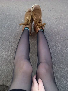Girl with Skinny Legs in Black Pantyhose Sitting on Asphalt