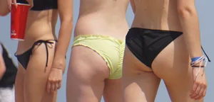 Sexy brunette in bikini playing football on the beach