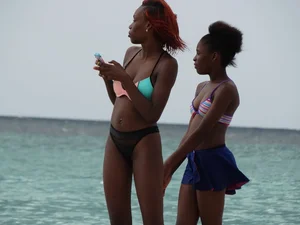 Candid black family, milf and teens on the beach in bikinis