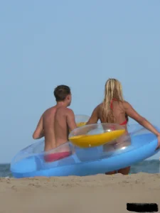 Sexy mom and daughter in red thongs at the beach
