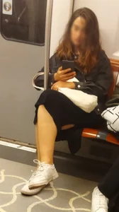 Girl in a Skirt Sitting With Crossed Legs in a Subway Train