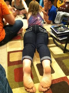 Barefoot teen candid girl in jeans lying on the floor