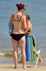 Tattooed redhead milf in a bikini at the beach