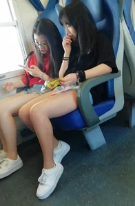 Two cute Asian teens on the bus in shorts showing their legs