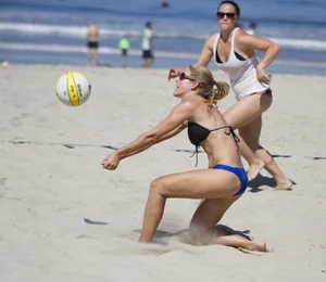 Hot girls playing beach volleyball in bikinis and shorts
