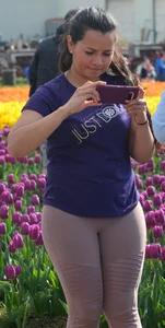 Cute babe in tight leggings taking pictures in flower fields