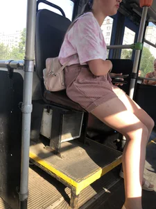 Young Girl in Sandals and Shorts in a Public Bus