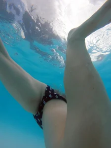 Underwater shots of a bikini teen swimming in the pool