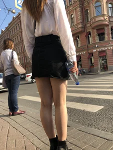 Awesome candid chick wearing a blouse and a skirt crossing the street on high heels, showing a little cheek