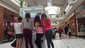 Little blonde teen in grey leggings at the mall with her friends