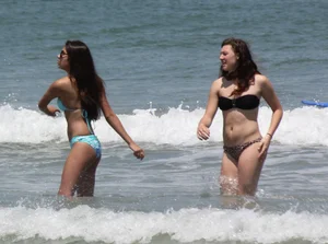 Brunette and redhead on the beach in bikinis looking sexy