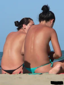 Bunch of sexy babes on the beach topless and in thong bikinis
