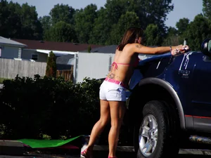 Group of cute girls at a car wash in bikinis and shorts