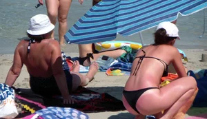 Amazing ass in semi-thong bikini on the beach with tanlines