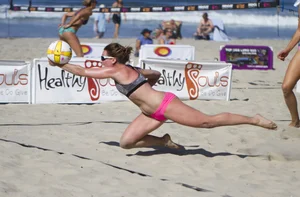 Hot girls playing beach volleyball in bikinis and shorts