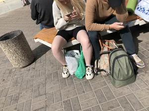 Teen wearing spandes shorts with very white skin sitting on a street bench creepshot