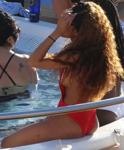 Sexy black girl in red swimsuit at the pool with side boob and a nice ass