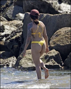 Sexy tattooed beach brunette with a great ass in yellow thong bikini
