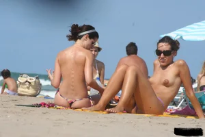 2 topless girls at the beach in thongs