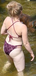 Chunky blonde enjoying some drinks in the water in her purple bikini