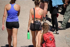 Tourist friends backpacking in shorts with vpl