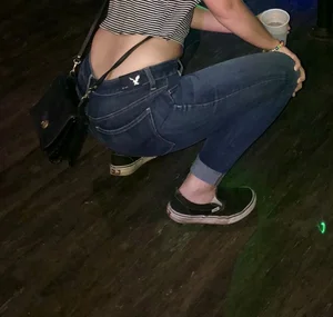 Slim Girl in Blue Jeans Squatting With Her Lower Back Showing