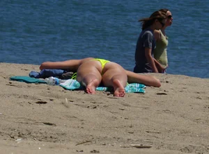 Sexy ass blonde milf on the beach in a thong with cameltoe and bending over