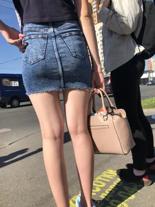 Cute Girl in a Short Denim Skirt Walking on a Street And Waiting on a Crosswalk Gallery