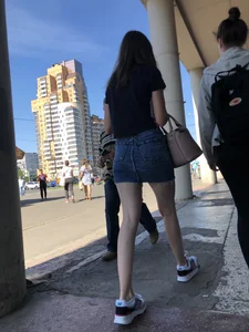 Cute Girl in a Short Denim Skirt Walking on a Street And Waiting on a Crosswalk Gallery