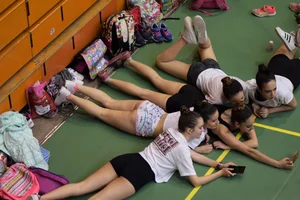 Teens Lying on the Ground in Shorts With Their Smartphones Candid Photo