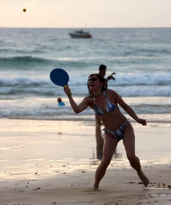 Older lady playing on the beach in her bikini