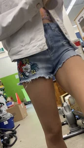 Tight bum hanging out of jean shorts in thrift shop