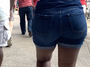 Bunch of girls in various outfits at a Cardinals baseball game