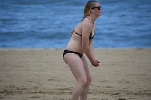 Chunky blonde in a black bikini on the beach