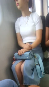 Cutie sitting in a public train creepshot, her legs slightly showing from under her skirt